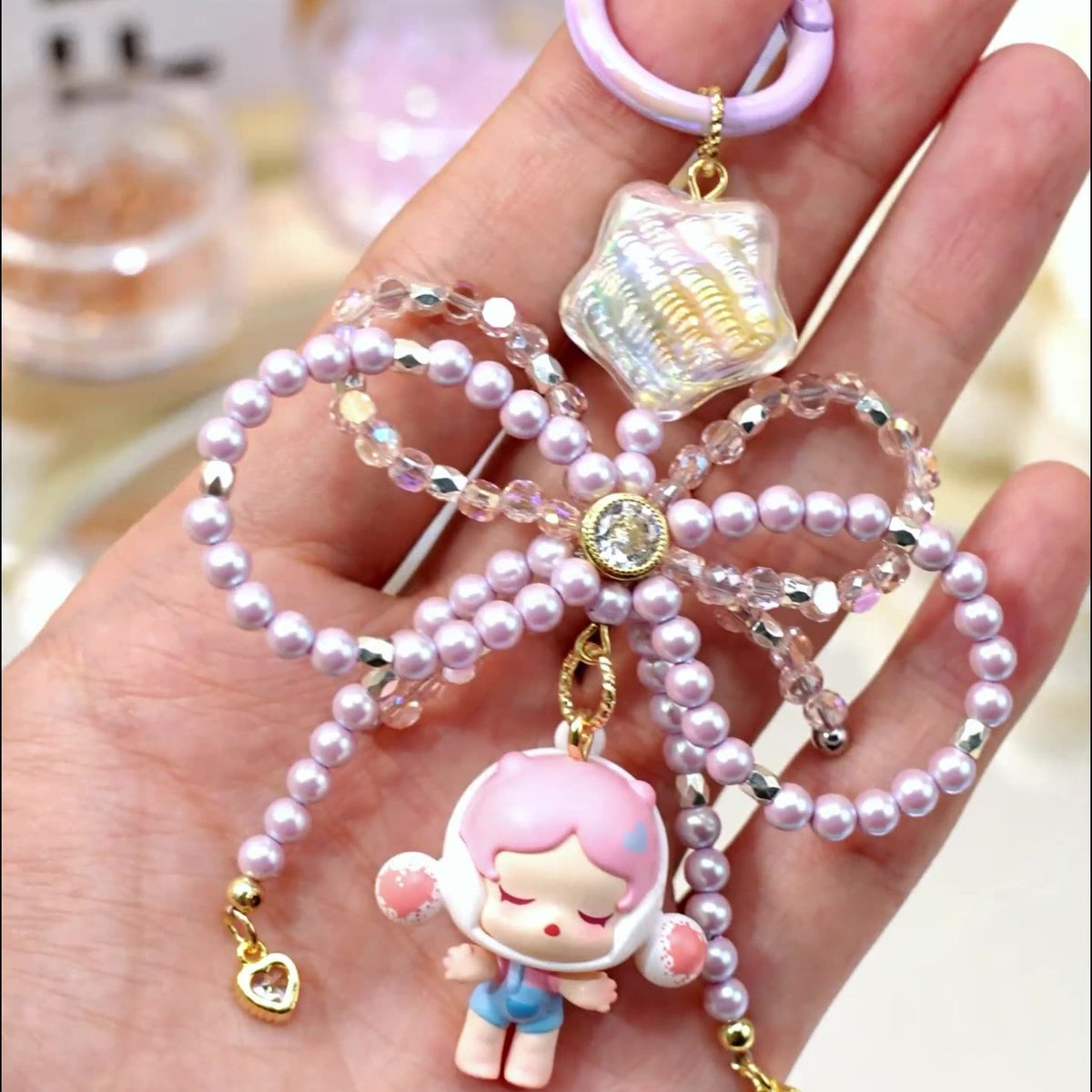 Iridescent star bead used above a decorative beaded bow and small doll charm in a finished accessory example