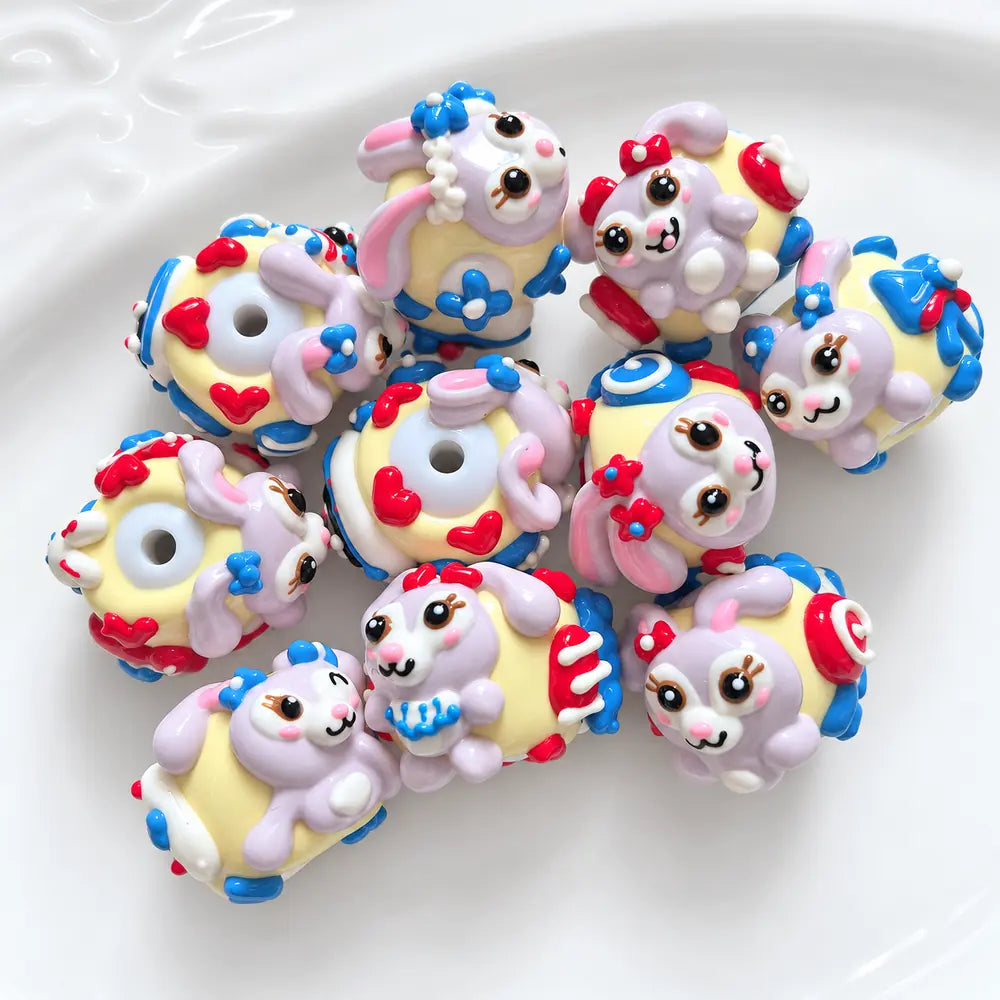 Ten hand-painted acrylic beads with lavender bunny designs, pale yellow bases, red hearts and blue flower details.