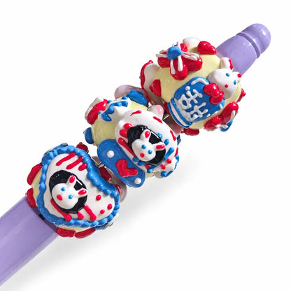 Ten hand-painted acrylic beads with lavender bunny designs, pale yellow bases, red hearts and blue flower details.