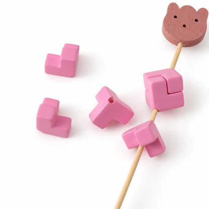 Rose pink acrylic puzzle bead pieces and an assembled square on a display rod, showing the holes and joins.