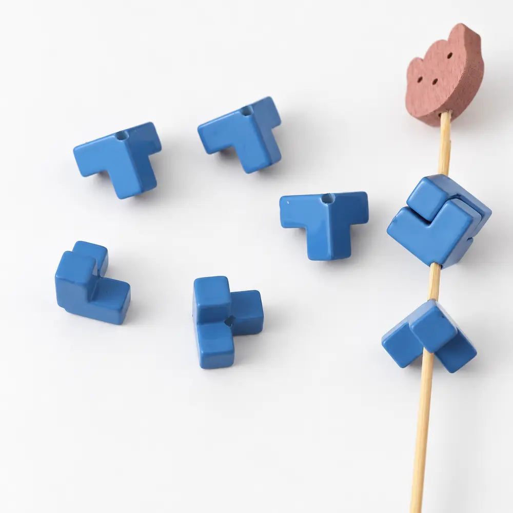 Dark blue acrylic puzzle beads shown separately and joined into a square, with visible threading holes.