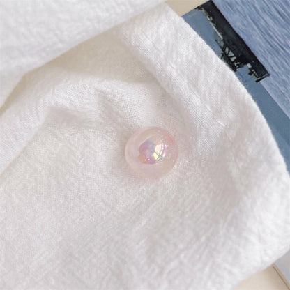 A pale pink acrylic round bead with an iridescent finish shown on textured white cloth in daylight.
