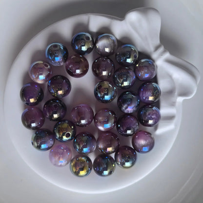 Dark iridescent acrylic round beads with glossy reflections and fine shimmer in a white bow-shaped dish.