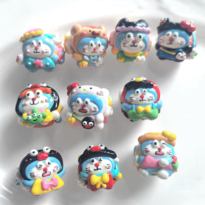 Set of 10 hand-painted acrylic beads with blue and white cat faces, colorful hats, bows and raised details.