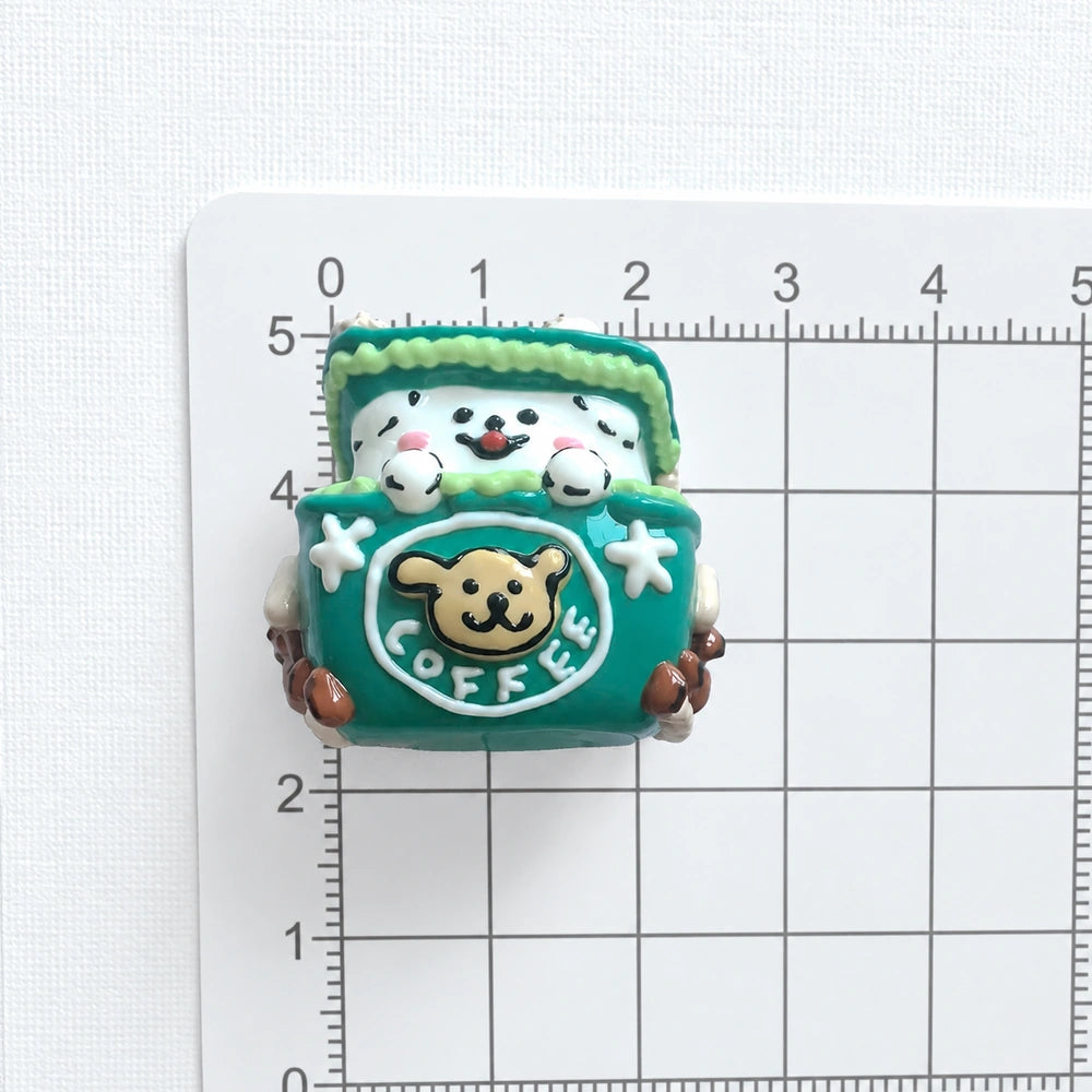 Front view of the puppy gift-box bead on a centimeter grid for approximate size reference.
