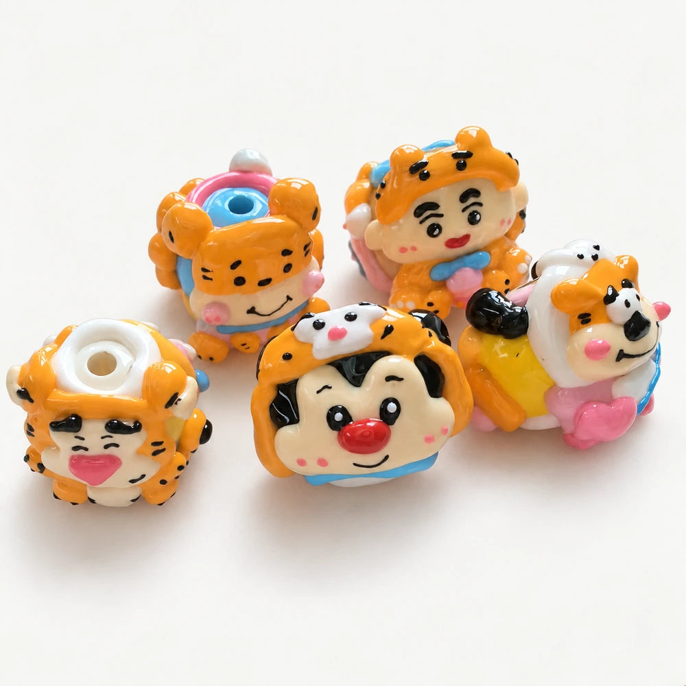 Five orange hand-painted acrylic beads showing expressive faces, spotted hoods and raised decorations.