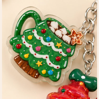 Close-up of the green Christmas tree mug-shaped charm with colorful decorations, white marshmallow-style details and silver-tone chain links.