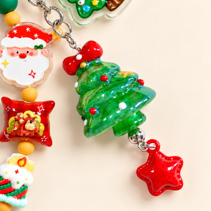 Close-up of the green dimensional Christmas tree charm with a red bow and dangling red star.