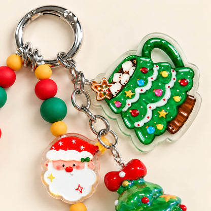 Close-up of the round spring clip, green Christmas tree mug-shaped charm and Santa face detail.