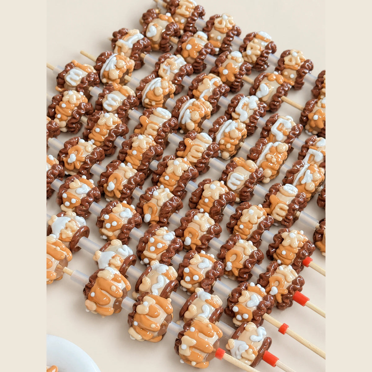Close-up of handmade light coffee brown 3D beads with glossy caramel and white raised details