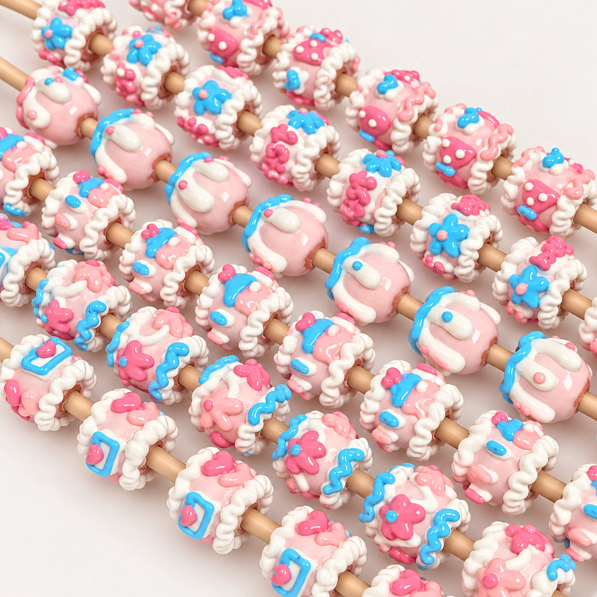 Hand-painted pastel pink, blue and cream raised 3D beads threaded on craft rods for beadable pen projects