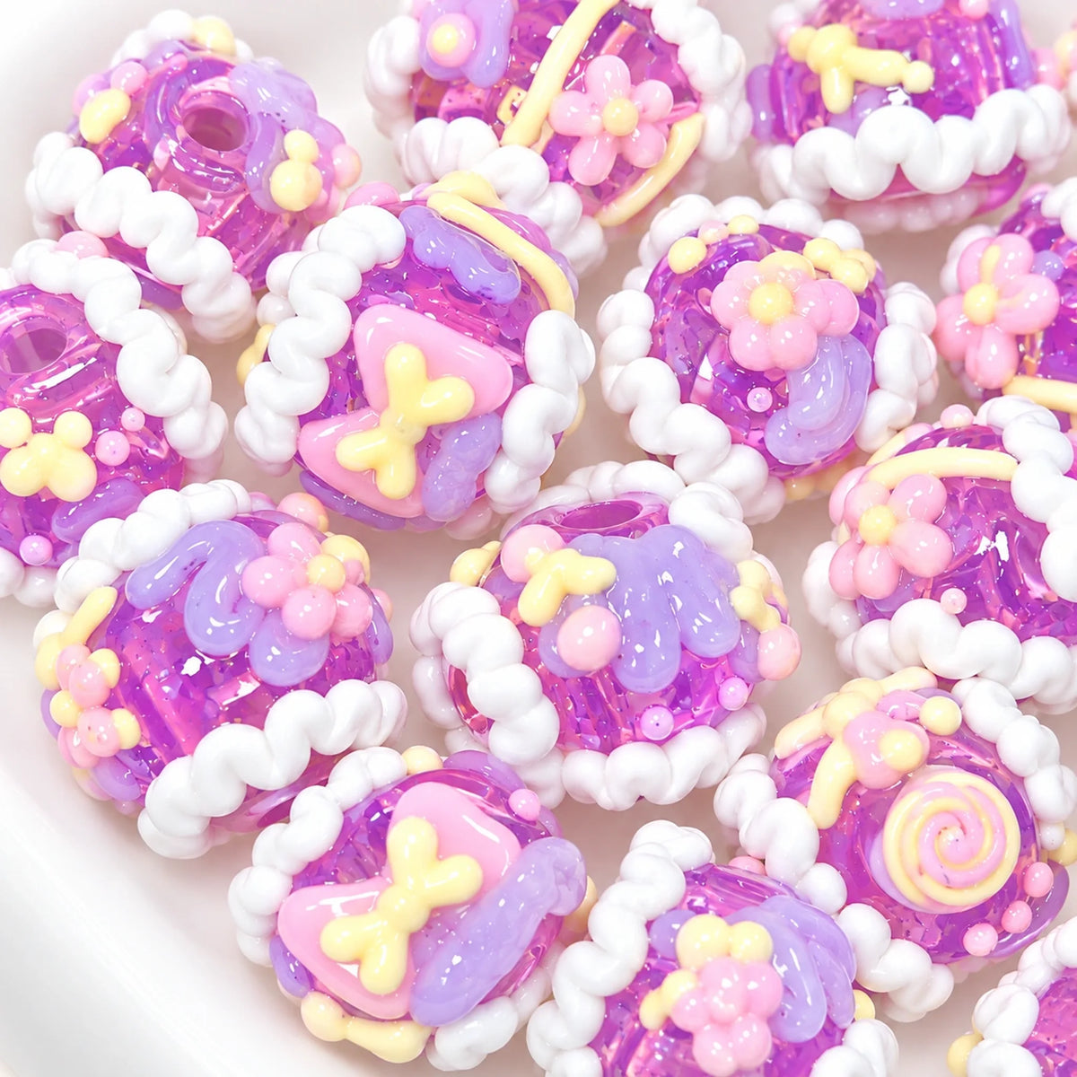 Close up assortment of taro grape purple translucent handmade 3D beads with raised pink yellow lilac patterns