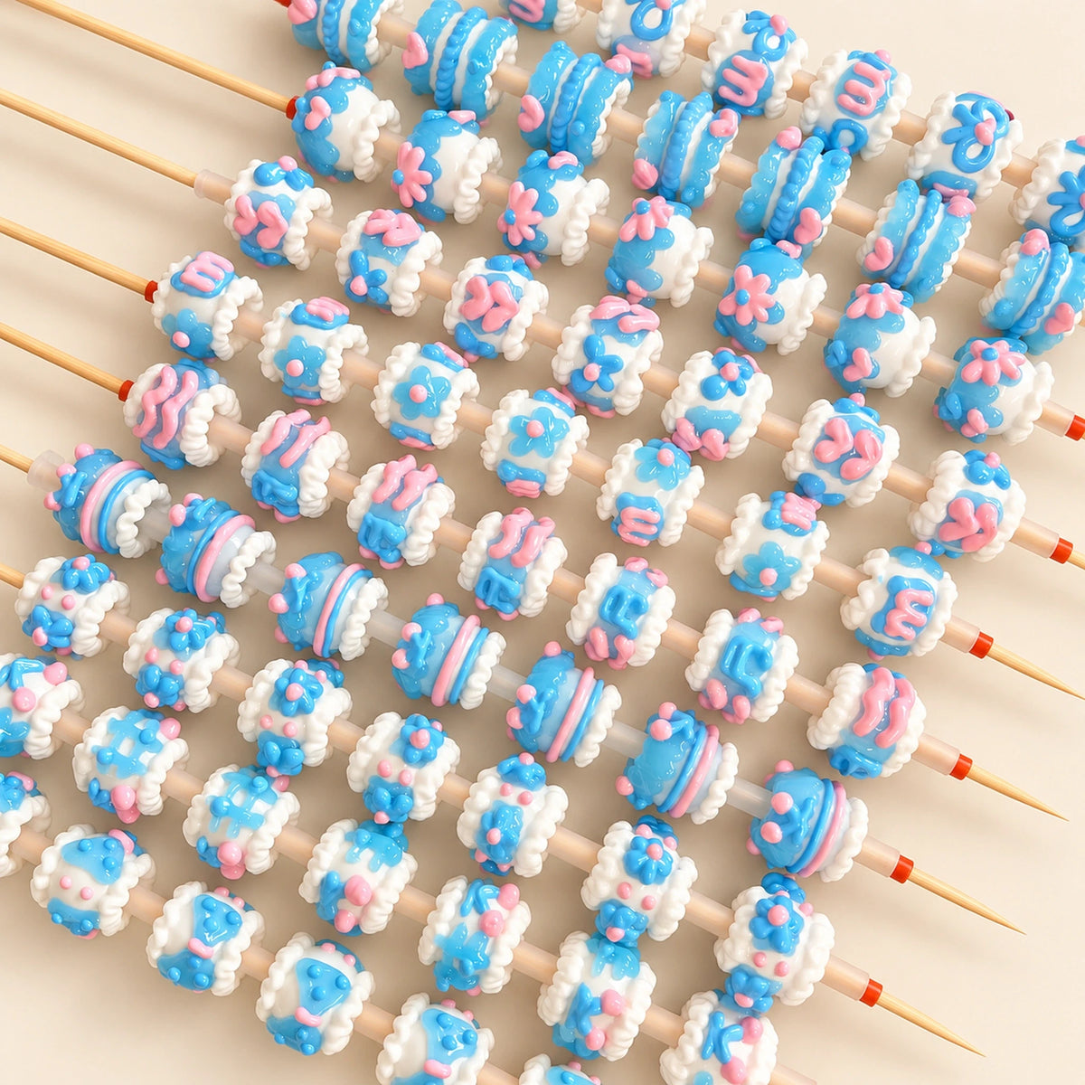 Blue jelly finish 3D handmade beads with white raised trim and pink accents threaded on bead pen rods
